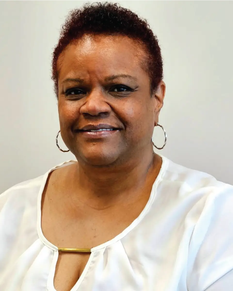 Darlene Hawkins in white blouse, smiling softly.